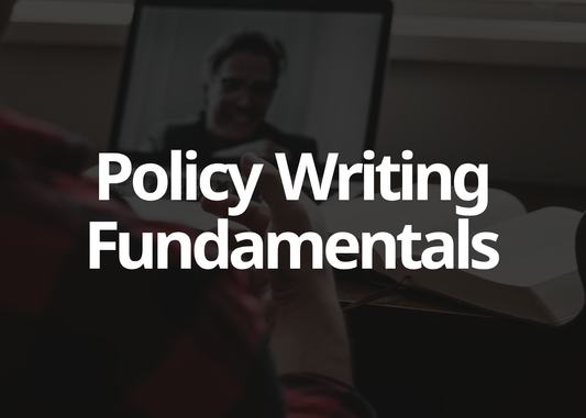 A dark promotional graphic with large white text reading 'Policy Writing Fundamentals' over a blurred scene of a person holding a pen and looking at a laptop.